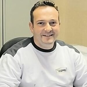 Ein Mann im wei&szlig;en Hemd sitzt an einem Schreibtisch und f&uuml;hrt Malerarbeiten durch. Thomas Jung Maler- &amp; Stukkateurbetrieb aus Spiesen