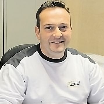 Ein Mann im wei&szlig;en Hemd sitzt an einem Schreibtisch und f&uuml;hrt Malerarbeiten durch. Thomas Jung Maler- &amp; Stukkateurbetrieb aus Spiesen