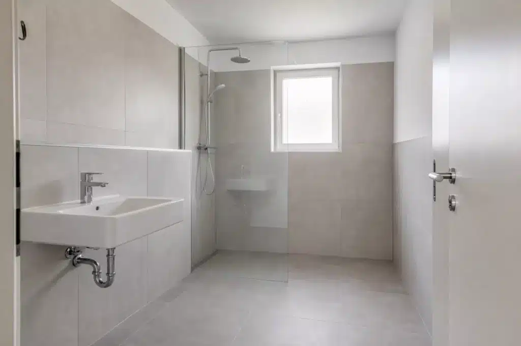 Nachher: komplett saniertes Bad mit großformatigen Fliesen und Walk-in-Dusche