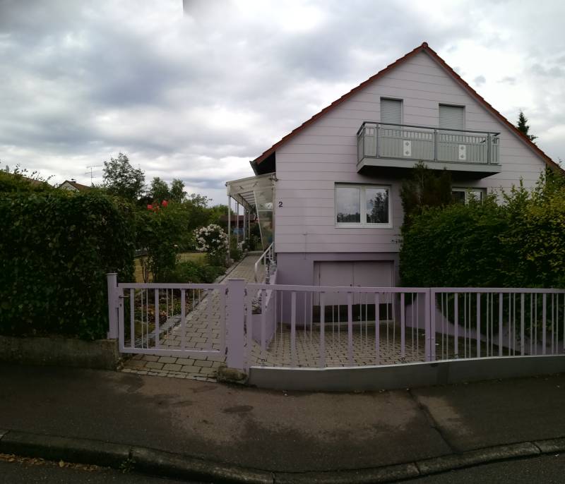 Fliederfarben gestrichenes Wohnhaus, Gesamtansicht mit Vorgarten